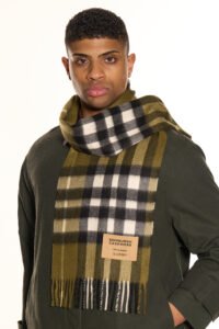 A stylized artistic arrangement of red and gold thistles surrounding a Thomson Red cashmere scarf.